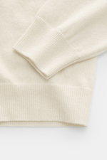 Close-up front view of Aida Barni Cashmere crew neck jumper cream sleeve and ribbed cuff, showcasing fine knit pattern and soft texture.