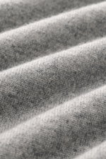 Close-up view of the finely knit fabric texture of the Brunello Cucinelli Cashmere pullover grey melange, highlighting its pure cashmere material.

<p>This timeless and versatile finely knit crew neck sweater by BRUNELLO CUCINELLI is made from pure cashme