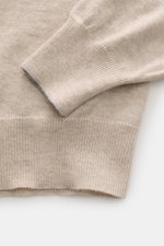 Nahaufnahme des Brunello Cucinelli Cashmere Rundhalspullover sand meliert, Detail von Ärmelsaum und feinem Strick aus weichem Cashmere.