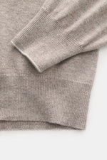 Nahaufnahme des Ärmels und Saums des Brunello Cucinelli Cashmere Rundhalspullover taupe meliert, feiner Strick mit schmalen Kontrastkanten.