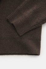 Close-up shot from above of The Row Crewneck sweater 'Anish' gray-brown melange showing textured pearl knit, ribbed cuffs, and soft cashmere-wool blend fabric.