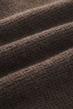 Close-up texture view of The Row Crewneck sweater 'Anish' gray-brown melange showing soft, textured pearl knit fabric with fine details.