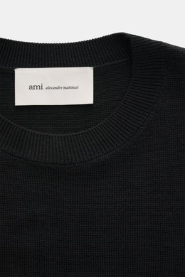 Ami Paris Merino Crew Neck Sweater Black shown from top close-up, featuring pure merino wool, soft touch, fine knit, crew neckline, ribbed cuffs, and logo stitching.
