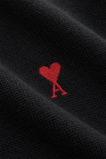 Close-up front view of the Ami Paris Merino Crew Neck Sweater Black showing fine knit texture and red chest logo stitch.