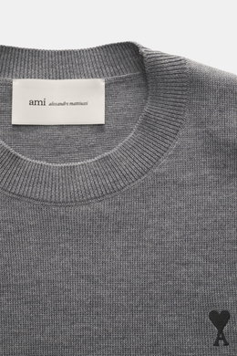 Nahaufnahme des Ami Paris Merino Rundhalspullover grau meliert von oben, zeigt feines Strickbild, weichen Griff, Rundhalsausschnitt, Rippbündchen und Logo-Stitching. Zeitloses Basic aus reiner Merinowolle, Regular Fit, ideal für Büro und Freizeit.