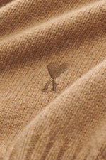 Close-up, angled view of the Ami Paris Cashmere crewneck sweater light brown fabric showing the soft medium-fine knit and tonal logo stitching.

Description: <p>Elegant essential from AMI PARIS: With this classic crewneck sweater made of luxurious cashmer