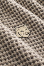 Maison Kitsuné Rundhalspullover "Fox Head" offwhite/grau/schwarz gestreift, Nahaufnahme von Waffel-Strickbild, reine Wolle, Fuchs-Motiv, Rippbündchen.