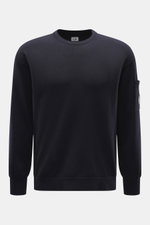 Vorderansicht des C.P. Company Rundhalspullover navy, Slim Fit mit Rundhalsausschnitt, Tasche am Oberarm, weicher Griff, feines Strickbild, flexible Rippbündchen, Mix aus Schurwolle und Microfaser, labeltypisches Linsen-Detail.