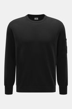 C.P. Company Rundhalspullover schwarz, Frontansicht, Slim Fit, Rundhalsausschnitt, Mix aus Schurwolle und Microfaser, weicher Griff, feines Strickbild, Tasche mit Druckknopf am Oberarm, labeltypisches Linsen-Detail, flexible Rippbündchen.