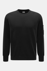 C.P. Company Rundhalspullover schwarz, Frontansicht, Slim Fit, Rundhalsausschnitt, Mix aus Schurwolle und Microfaser, weicher Griff, feines Strickbild, Tasche mit Druckknopf am Oberarm, labeltypisches Linsen-Detail, flexible Rippbündchen.