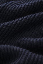 C.P. Company Rundhalspullover navy in Nahaufnahme, zeigt mittelfeines Strickbild, weichen Griff, Patent-Muster, Slim Fit, Rundhalsausschnitt, Oberarmtasche mit Zipper, Linsen-Detail, flexible Rippbündchen, Strick aus Schurwolle und Microfaser.
