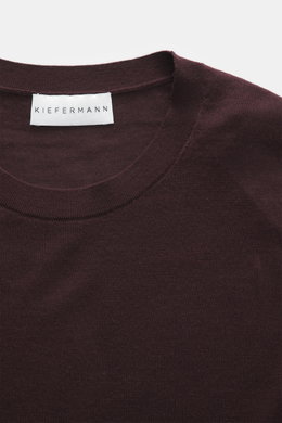 Close-up top view of the burgundy Kiefermann Merino Crewneck Sweater 'Marleys' showing the crew neckline, fine knit pattern, and label, a luxurious basic piece made of pure Merino wool with a soft touch and slim fit, perfect for layering on cold days.