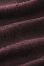 Close-up, macro shot of the fine-knit burgundy fabric of the Kiefermann Merino Crewneck Sweater 'Marleys' showing soft texture and detail.
