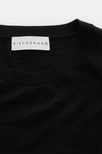Close-up front view of the Kiefermann Merino crew neck sweater 'Marleys' black, showcasing its crew neckline, soft touch, pure merino wool, very fine knit pattern, and slim fit design. Luxurious basic piece ideal for layering on cold days.