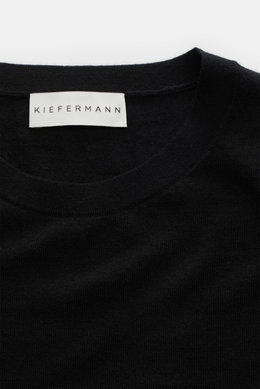 Close-up front view of the Kiefermann Merino crew neck sweater 'Marleys' black, showcasing its crew neckline, soft touch, pure merino wool, very fine knit pattern, and slim fit design. Luxurious basic piece ideal for layering on cold days.