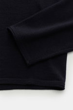 Close-up view of the sleeve and hem of the Kiefermann Merino Fine Knit Sweater 'Benjaminn' navy, showcasing pure merino wool, super soft feel, very fine knit pattern, slim fit, round neckline, and open, rolled edge finishes.