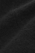 Nahaufnahme des feinen Strickbilds und sehr weichen Griffs des Filippo de Laurentiis Rundhalspullover schwarz, Mix aus Cashmere, Seide und Microfaser, Regular Fit, Rundhalsausschnitt, komfortable Rippbündchen, fotografiert aus seitlicher Perspektive.