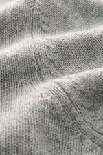 Nahaufnahme des mittelgroben Strickbilds des Allude Rundhalspullover grau meliert aus Wolle und Cashmere mit weichem Griff, fotografiert in Detailperspektive.