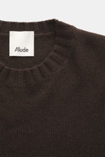 Nahaufnahme von Allude Rundhalspullover dunkelbraun mit Rundhalsausschnitt, komfortablen Rippbündchen, Regular Fit, mittelgrobes Strickbild, weicher Griff, Mix aus Wolle und Cashmere, von oben fotografiert.