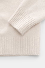 Detailaufnahme des Bruno Manetti Cashmere Rundhalspullover sand von schräg oben, zeigt weiches, feines Strickbild, Extra Slim Fit, Rundhalsausschnitt und komfortable Rippbündchen aus reinem Cashmere.