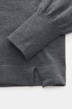 Nahaufnahme des Officine Générale Merino Rundhalspullover graublau meliert, Detailfoto von Ärmel und Saum aus reiner Merinowolle mit feinem Strickbild, weichem Griff, Regular Fit, Rundhalsausschnitt und komfortablen Rippbündchen, fotografiert von oben.