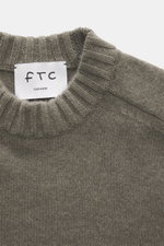 Nahaufnahme des FTC Cashmere Rundhalspullover graugrün meliert von oben, mittelfeines Strickbild, Rundhalsausschnitt, OEKO-TEX®-zertifizierter, nachhaltiger Luxus.