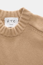 Nahaufnahme von FTC Cashmere Rundhalspullover beige mit mittelfeinem Strickbild, Rippbündchen und Label, nachhaltiger Luxus aus reinem Cashmere.