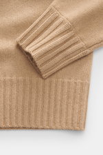 Nahaufnahme des FTC Cashmere Rundhalspullover beige von oben fotografiert, Fokus auf Rippbündchen und mittelfeines Strickbild.