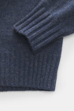 Nahaufnahme des FTC Cashmere Rundhalspullover graublau meliert, seitlich fotografiert, zeigt weiche Cashmere-Qualität, Slim Fit mit Rippbündchen.