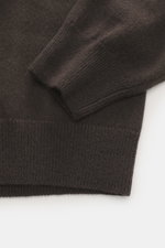 Close-up view of the sleeve and hem of the FTC Cashmere Crew Neck Sweater dark brown showing pure cashmere, very soft touch, fine knit pattern, slim fit, crew neckline, and ribbed cuffs.