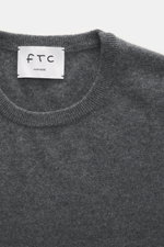 FTC Cashmere Crew Neck Sweater grey melange shown from a top close-up view with crew neckline, ribbed cuffs, fine knit, slim fit, pure cashmere.