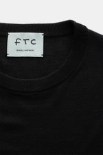 Nahaufnahme des Rundhalsausschnitts vom FTC Feinstrick-Rundhalspullover schwarz, Mix aus Cashmere und Lyocell, Slim Fit, sehr feiner Strick, weicher Griff, OEKO-TEX® Standard 100, komfortable Rippbündchen.