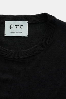 Nahaufnahme des Rundhalsausschnitts vom FTC Feinstrick-Rundhalspullover schwarz, Mix aus Cashmere und Lyocell, Slim Fit, sehr feiner Strick, weicher Griff, OEKO-TEX® Standard 100, komfortable Rippbündchen.