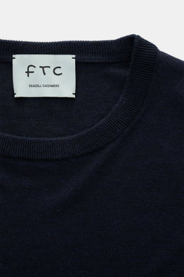 Nahaufnahme des FTC Feinstrick-Rundhalspullover navy mit Rundhalsausschnitt, Slim Fit, weichem Griff, feinem Strickbild, Rippbündchen, Mix aus Cashmere und Lyocell, OEKO-TEX® Standard 100 zertifiziert, von oben fotografiert.