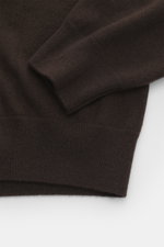 Close-up of the sleeve and bottom hem of the Moorer Cashmere crewneck sweater 'Orvieto-WY' dark brown, showing its fine knit pattern, soft texture, and flexible ribbed cuffs from a top-down perspective. Luxurious comfort in perfection: This classic crewne