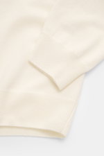 Close-up top view of the sleeve and hem of the Moorer Cashmere crewneck sweater 'Orvieto-WY' cream, made from pure cashmere with a soft feel, fine knit pattern, slim fit, crew neckline, and flexible ribbed cuffs.