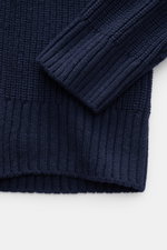 Nahaufnahme des Closed Rundhalspullover navy aus edlem Wollstrick mit schwerem Patentstrickmuster, Rippbündchen, Raglanärmel und Regular Fit, perspektivisch von oben fotografiert.