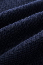 Nahaufnahme des edlen Wollstricks in klassischem Patentstrick des Closed Rundhalspullover navy mit schwerem Strickbild, aufgenommen aus Draufsicht.