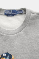 Nahaufnahme von Polo Ralph Lauren Sweatshirt 'Polo Bear' grau meliert, Rundhalsausschnitt, weicher Griff, komfortable Rippbündchen, Vintage Fit.