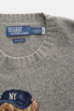 Graue Nahaufnahme des Polo Ralph Lauren Rundhalspullover grau meliert mit weichem Wolle-Cashmere-Mix, Rippbündchen und Polo-Bear-Intarsie.