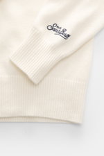 Nahaufnahme des Ärmels vom MC2 Saint Barth Rundhals-Pullover 'Heron Print' creme/multicolor, weicher Griff, mittelfeines Strickbild, Slim Fit, Rippbündchen mit Logo-Stitching.