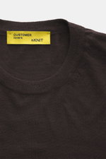 Close-up front view of B.F. Knitwear Merino Crew Neck Sweater dark violet, showing crew neckline and yellow label, made of pure merino wool, soft feel, fine knit pattern, regular fit, and comfortable ribbed cuffs.