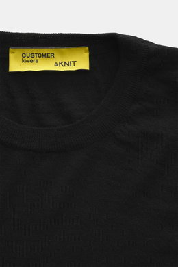 Close-up front view of the B.F. Knitwear Merino Crew Neck Sweater black showing crew neckline, pure merino wool, soft feel, fine knit pattern, regular fit, and comfortable ribbed cuffs.