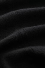 Nahaufnahme des schwarzen Colombo Rundhalspullover aus Kid Wool, zeigt feine Strickstruktur, weichen Griff und Rippbündchen.