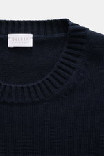 Close-up top-down view of the navy 04651/ A trip in a bag Crew neck sweater 'Wintercotton Pocket Crew' showing medium-fine knit, soft blend of cotton and wool, slim fit, crew neckline, contrasting chest pocket, and comfortable ribbed cuffs.