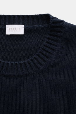 Close-up top-down view of the navy 04651/ A trip in a bag Crew neck sweater 'Wintercotton Pocket Crew' showing medium-fine knit, soft blend of cotton and wool, slim fit, crew neckline, contrasting chest pocket, and comfortable ribbed cuffs.