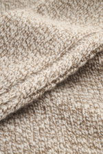 Nahaufnahme des voluminösen Strickbilds von 04651/ A trip in a bag Rundhalspullover 'Donegal Cable Crew' creme/taupe meliert, Detailansicht des weichen Griffs, Zopfstrick-Muster am Arm, Raglanärmel, Rundhalsausschnitt und komfortable Rippbündchen, aus Sch