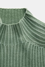 04651/ A trip in a bag Mock Neck Pullover 'Foggy' grün, Nahaufnahme von oben auf Stehkragen und mittelfeines Patent-Strickmuster aus weicher Schurwolle.