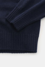 Nahaufnahme des navyfarbenen 04651/ A trip in a bag Cashmere Rundhalspullover 'Extreme Cashmere Crew' mit feinem Strick und Rippbündchen, fotografiert von oben.