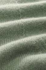 Nahaufnahme des feinen, luftigen Strickbildes des 04651/ A trip in a bag Cashmere Rundhalspullover 'Extreme Cashmere Crew' hellgrün aus reinem Cashmere, fotografiert aus seitlicher Perspektive.